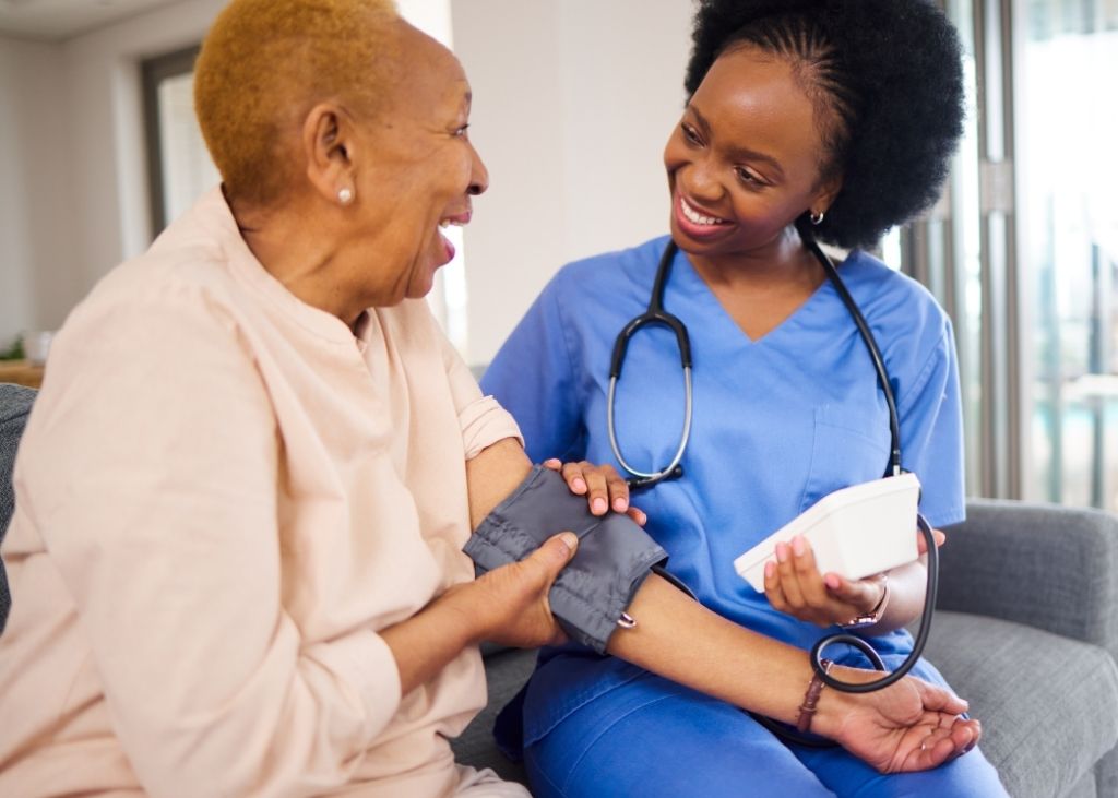 Nurse checking blood pressure of elderly patient