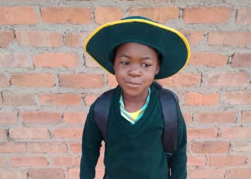 Child in green school uniform with backpack